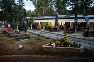 een groep tafels en parasols in een park bij Kemp Sluníčko in Doksy