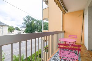 einen Balkon mit einem rosa Stuhl und einem Tisch in der Unterkunft Le Daubenton in Dijon