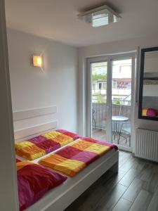 1 dormitorio con 1 cama con una manta colorida en Apartamenty i Pokoje Gracja Miedzyzdroje, en Międzyzdroje