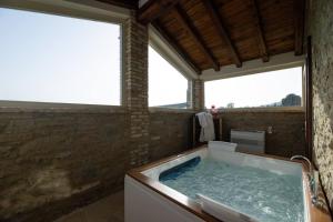 a bath tub in a room with two windows at Villetta Montalla in Cortona