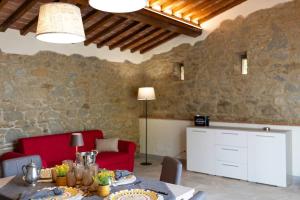 a living room with a table and a red couch at Villetta Montalla in Cortona