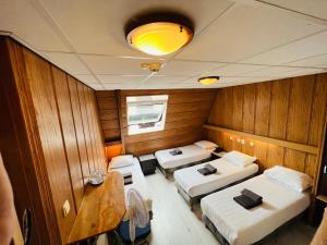 une petite chambre avec 3 lits dans un bateau dans l'établissement Hotel Sharm, à Amsterdam