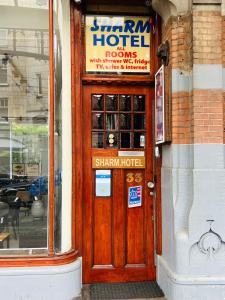 una porta di legno di un hotel con un cartello sopra di Hotel Sharm ad Amsterdam