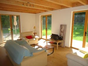a living room with two couches and a tv at cottage pleine nature in Wattwiller