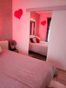 um quarto com duas camas com corações na parede em Miss G'Ainguette em Guéreins