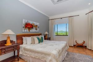 um quarto com uma cama e uma janela em Boungainvillea 1203 Luxury Apartment - Reserva Conchal em Playa Conchal