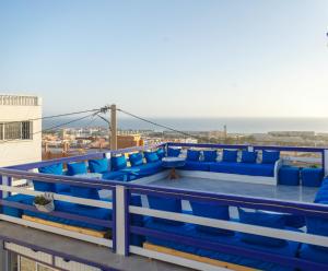 a balcony with blue chairs and the ocean in the background at The Rina Hostel in Agadir