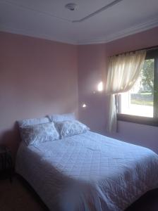 a bedroom with a white bed with a window at Residencial Pine House in Canela