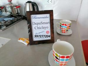 a sign sitting on a counter next to two cups at Departamento-Bolognesi B1 in Chiclayo