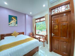 a bedroom with a bed and a window and a door at Van Anh Hotel - Restaurant in Dồng Văn