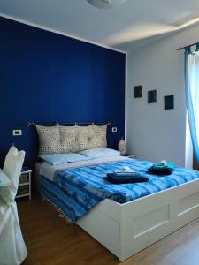 a bedroom with a bed with a blue wall at Alley 8 in Scilla
