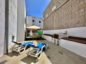 un patio con due sedie, un tavolo e un ombrellone di Casa Tina a Güímar