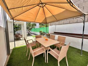 a table and chairs under an umbrella on a lawn at Casa Tina in Güimar