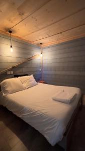 Cette chambre comprend un grand lit blanc. dans l'établissement Le Gîte les NUZ ( parc du château de Keroüartz), à Lannilis