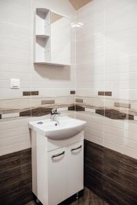 uma casa de banho branca com um lavatório e um espelho em Къща за гости Давиос em Sapareva Banya