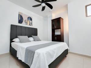 a bedroom with a large bed with a ceiling fan at Apartamentos cerca a la playa, Los Laureles - By Bedviajes in Santa Marta
