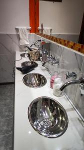 a bathroom counter with three sinks in a bathroom at Antarctica Hostel in Ushuaia