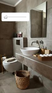 y baño con lavabo, aseo y espejo. en Epos Villas & Luxury Studios en Paliouri