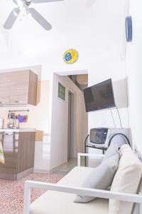 ein Wohnzimmer mit einem weißen Sofa und einem TV in der Unterkunft Casa Rosalba in Noto
