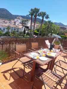 ein Holztisch und Stühle auf einer Terrasse in der Unterkunft Mirador de Alhaurín Loft City Center in Alhaurín de la Torre