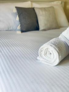 a roll of white towels sitting on a bed at Lydia House in Korinthos