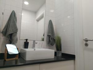 a bathroom with a white sink and a mirror at Enjoy Viseu in Viseu