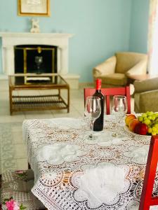 uma mesa com dois copos de vinho e fruta em Lydia House em Corinto