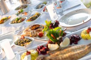 a table with many plates of food on it at Etenna Beach Bungalows in Cıralı +114 photos