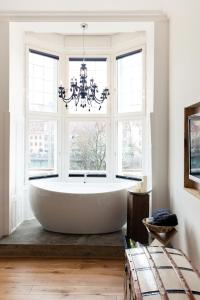 eine große Badewanne in einem Zimmer mit Fenstern in der Unterkunft Grand Hôtel Wiesler - Centre of Graz in Graz