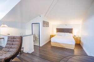 a bedroom with a white bed and a chair at Hotel Callista in Norwich