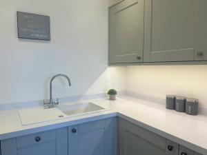 een keuken met blauwe kasten en een wastafel bij Black Horse Apartments in Knaresborough
