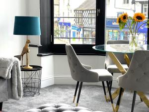 comedor con mesa de cristal y sillas en Black Horse Apartments, en Knaresborough
