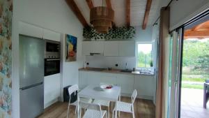 a kitchen with a white table and chairs at La Flor de Agua in Torielló
