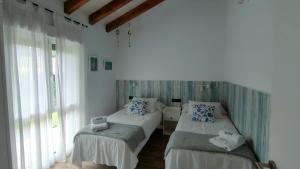 1 Schlafzimmer mit 2 Betten und einem Fenster in der Unterkunft La Flor de Agua 