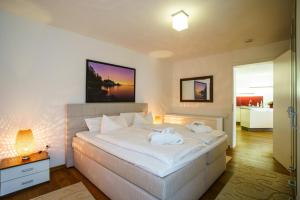 1 dormitorio con 1 cama blanca grande y toallas. en Hotel Holsteiner Hof GmbH en Timmendorfer Strand