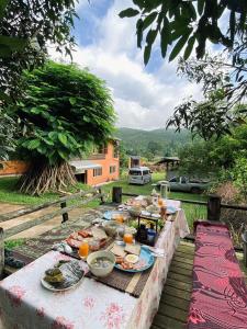 une table avec des assiettes de nourriture au-dessus dans l'établissement The Maewin Coffee & Cottage Economy Double Room, à Ban Huai Rin