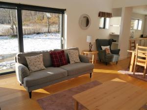 een woonkamer met een bank en een tafel bij Laundry Cottage in Aberlour
