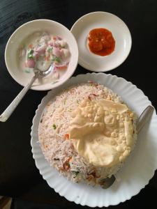 a table with plates of food and a plate of rice at City Square in Deoghar