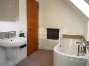een badkamer met een wastafel en een ligbad bij Laundry Cottage in Aberlour +34 foto's