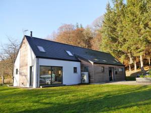 een huis met een zwart dak op een groen veld bij Laundry Cottage in Aberlour