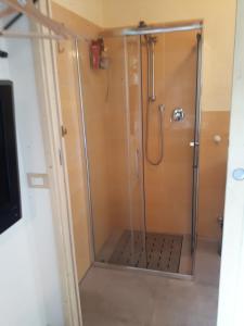 um chuveiro com uma porta de vidro na casa de banho em Casalotto Francescano em Mengara