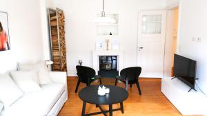 a living room with a white couch and a table at Elbperle! Zentrales Apartment an der Elbe in Hamburg