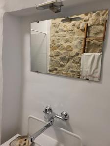 a mirror above a sink in a bathroom at Dézsavár Vendégház in Majs