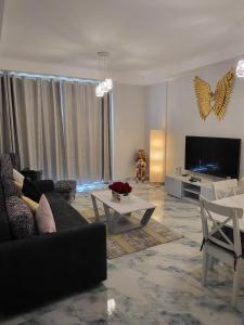 sala de estar con sofá y TV en Summer By The Sea Ultra Luxe 1 bedroom Apartment with a private beach - Al Marjan Island, en Ras al Khaimah