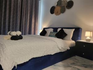 a bedroom with a blue and white bed with pillows at Summer By The Sea Ultra Luxe 1 bedroom Apartment with a private beach - Al Marjan Island in Ras al Khaimah