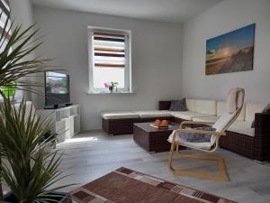 a living room with a couch and a tv at FeWo s Runde Wiese WR in Greifswald