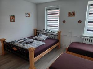 1 Schlafzimmer mit 2 Betten und 2 Fenstern in der Unterkunft FeWo s Runde Wiese WR in Greifswald