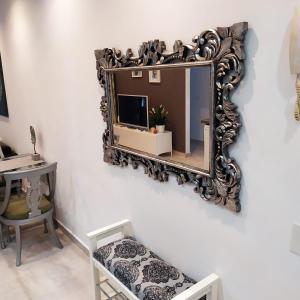 德爾錫倫西奧海岸的住宿－Cosy 2 bedroom near sea Costa del Silencio，墙上的镜子,配有椅子和书桌