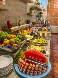 uma linha de buffet com muitos pratos de frutas e legumes em LS Villas Hotel & Spa em Águas de São Pedro