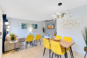un soggiorno con tavolo da pranzo e sedie gialle di Ocean 2 - Seaside boutique a Indian Harbour Beach